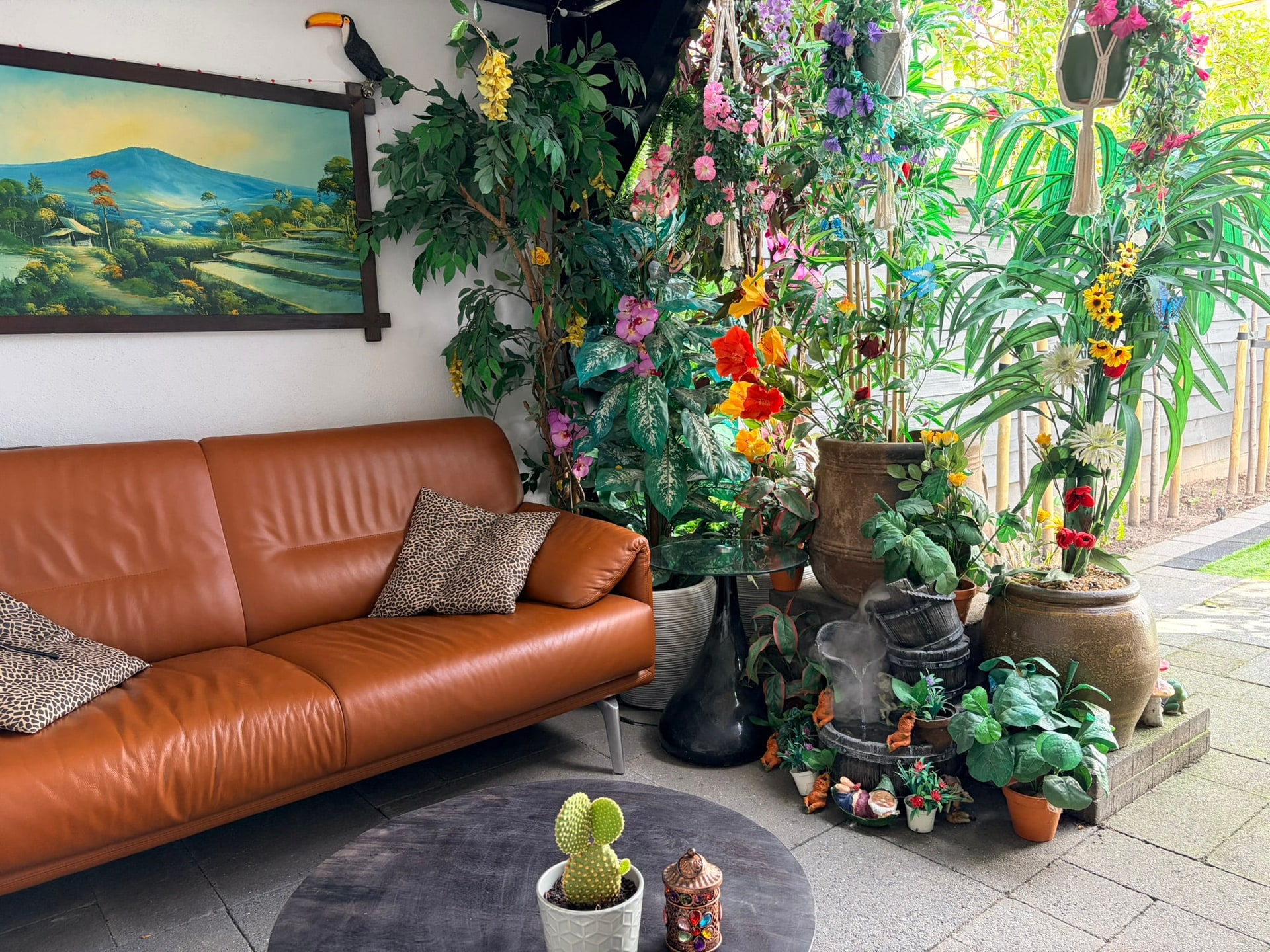 Dezelfde hoek van de tuin overdag, met de bank en de wand van planten